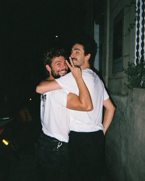 two friends hugging on a street at night
