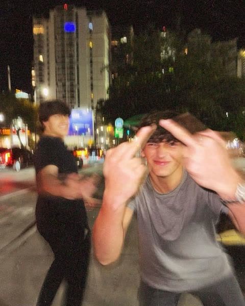 a boy dancing in the street at night, motion blur